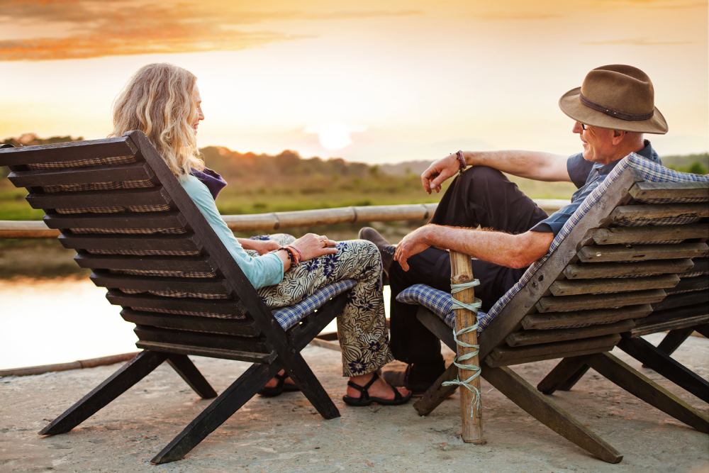 A senior couple sitting outside at sunset